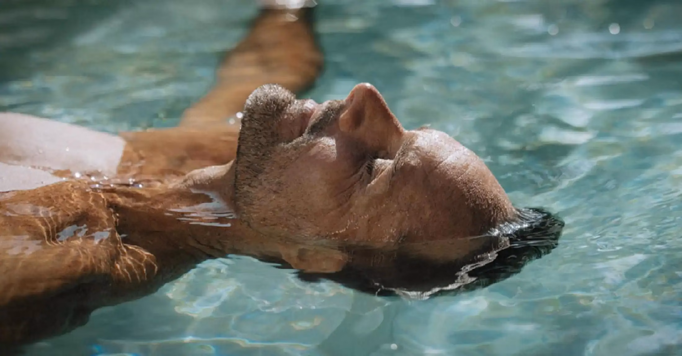 A man relaxing with his eyes closed in a pool at Mana Sanctuary Bali wellness retreat