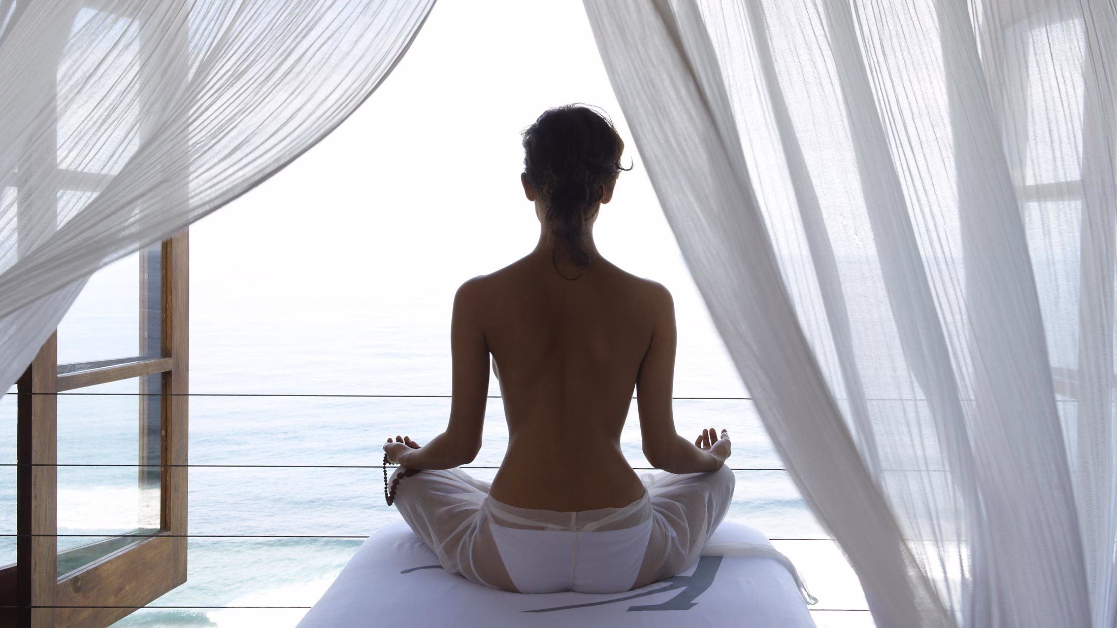 beautiful girl facing the ocean in a yoga pose